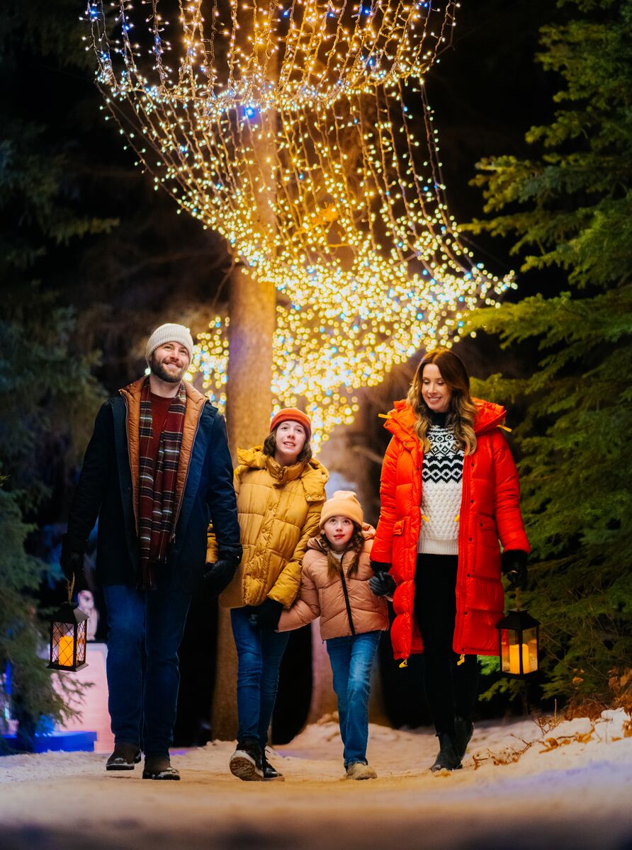 A family amongst Christmas lights at In Search of Christmas Spirit in Banff National Park.